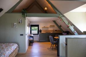a room with a bed and a kitchen in a attic at DuinDroom bovenappartement, Beverwijk in Beverwijk