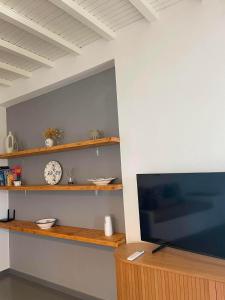 ein Zimmer mit einem Fernseher und einer Uhr an der Wand in der Unterkunft Stivari view in Batsi