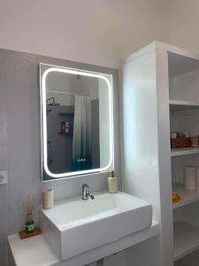 ein weißes Badezimmer mit Waschbecken und Spiegel in der Unterkunft Stivari view in Batsi + 31 Fotos