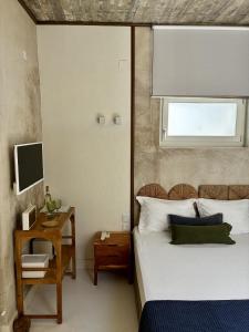 a bedroom with a bed and a desk and a television at Synoikies by Oikieskiathos in Skiathos