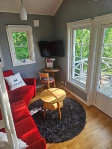 ein Wohnzimmer mit einem roten Sofa und einem Tisch in der Unterkunft Toppstugan in Åkerö