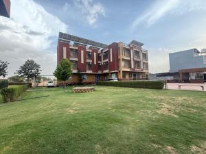 a large building with a grass field in front of it at Amar mahal hotel and restaurant in Khātu