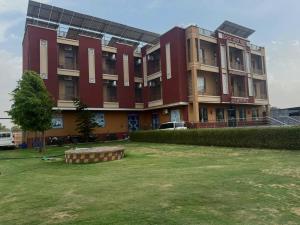 a large red building with a lawn in front of it at Amar mahal hotel and restaurant in Khātu