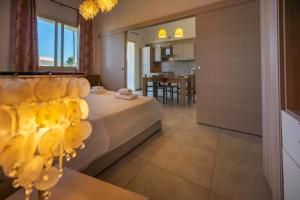 a bedroom with a bed and a dining room at Villa Fontane Bianche in Fontane Bianche