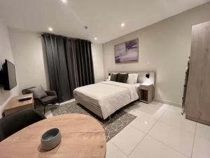 a hotel room with a bed and a table in it at Green Palm Resort Lekki in Ikuata