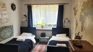 two beds in a room with a window at Happy One Park Apartment in Świdnica