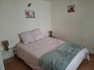a small bedroom with a bed and two pictures on the wall at La Maison du Cordonnier in Fréland
