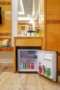 an open refrigerator in a kitchen with a counter at Hotel Urban ECG Grand - Inn Near IGI Delhi Airport in New Delhi