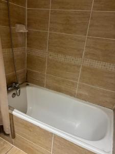 a bath tub in a bathroom with a tiled wall at Casa El Manantial in Vallenar