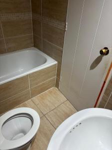 a bathroom with a toilet and a bath tub at Casa El Manantial in Vallenar +2 photos