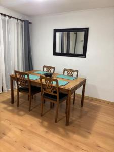 a dining room table with two chairs and a mirror at Casa El Manantial in Vallenar