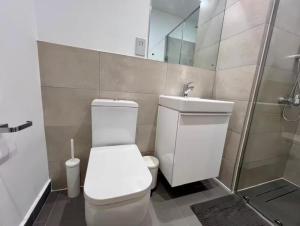 a bathroom with a toilet and a sink and a shower at Green Palm Resort Lekki in Ikuata