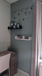 a room with a blue wall with shelves and a table at Chambre studio in Sublaines