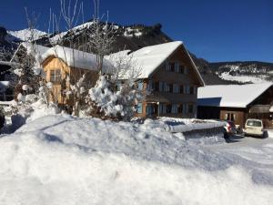ein schneebedecktes Haus mit einem Schneehaufen in der Unterkunft Küferhof in Mellau