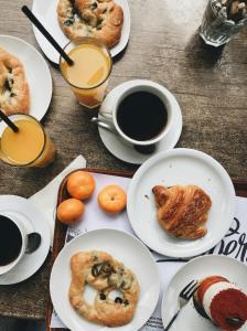 a table with plates of pastries and cups of coffee at Hotel Urban ECG Grand - Inn Near IGI Delhi Airport in New Delhi +33 photos