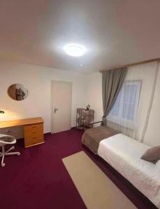 a bedroom with a bed and a desk and a window at Adriaapartman in Bad Wörishofen