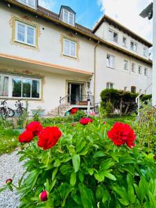 a house with red flowers in front of it at Adriaapartman in Bad Wörishofen