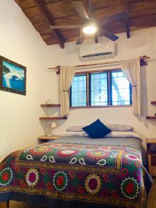 a bedroom with a bed with a colorful bedspread at Tres Corazones in Carrillo +76 photos
