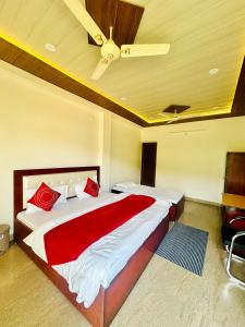 a bedroom with a bed with red pillows and a ceiling at Hotel Mount View in Haldwāni
