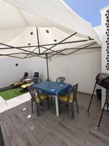 a table and chairs under a white umbrella at MahdiaRafeha in Mahdia