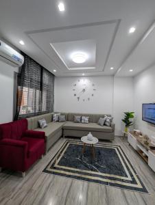 a living room with a couch and a clock on the wall at MahdiaRafeha in Mahdia