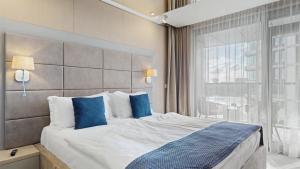 a bedroom with a large bed with blue pillows at Eurovea Apartments in Bratislava