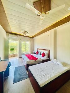 a bedroom with two beds and a ceiling fan at Hotel Mount View in Haldwāni