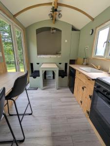 a small kitchen with a sink and a table at Kingfisher Shepherd's Hut in Saint-Mars-sur-la-Futaie
