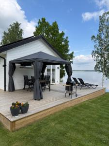 a gazebo on a deck next to the water at Villa Guldkusten in Kolsva