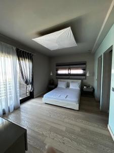 a bedroom with a white bed and a ceiling with a window at VILLA KTIMA MELINA Pelio ΒΙΛΑ ΜΕ ΠΙΣΙΝΑ ΒΟΛΟΣ ΠΗΛΙΟ in Álli Meriá +88 photos