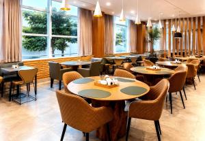 a restaurant with tables and chairs and windows at ibis Catanduva in Catanduva