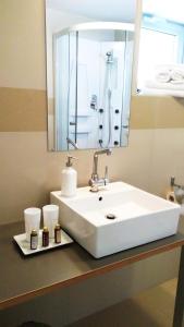 lavabo blanco en el baño con espejo en Villa Green, en Sliač