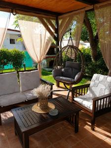 a patio with a couch and a swing and a table at Noufara Apartments in Nea Mesangala