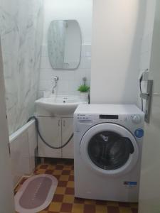 a bathroom with a washing machine and a sink at Apartman Centar Lux in Pirot +11 photos