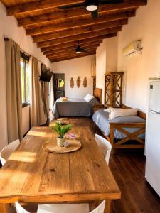 a dining room with a wooden table and a bed at Algarrobos del Mirador in Santa Rosa de Calamuchita +100 photos