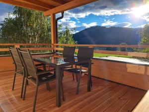 a wooden deck with a table and chairs on it at Graglerhof in Liebenfels