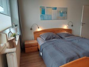 a bedroom with a bed with blue sheets and two lamps at NordseeGlück in Cuxhaven