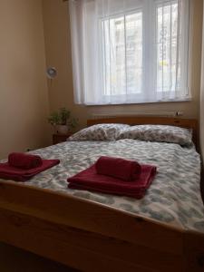 a bed with two red towels on top of it at Daniel Apartment in Reda +6 photos