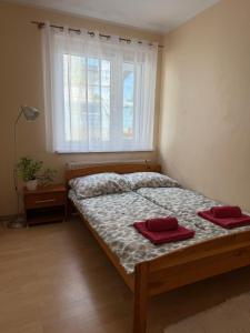 a bedroom with a bed with two red towels on it at Daniel Apartment in Reda