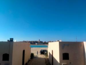 a view of the beach from between two buildings at غرفتين و ترأس بالاندلسية in Marsa Matruh