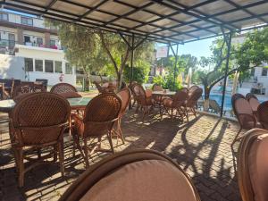 an outdoor patio with tables and chairs and a table at Bena pansiyon in Fethiye