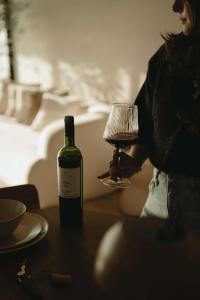 a woman holding a wine glass next to a bottle of wine at Kasa Dharma an oceanfront House in El Suazal +51 photos