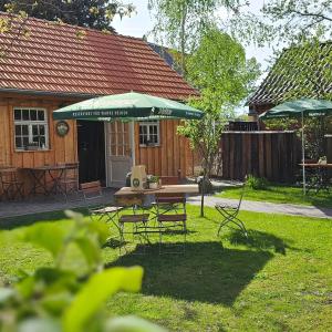 a patio with a table and chairs and an umbrella at Hofidyll Burg - ruhige 75qm FeWo im Zentrum mit Terrasse & Biergarten - bis 6 Personen in Burg