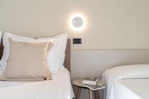 a bedroom with two beds and a side table with a lamp at Hotel Estense in Gatteo a Mare