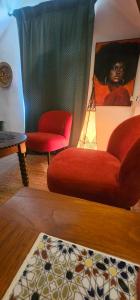 a living room with a red couch and two chairs at LES GARGOUILLES - Piscine à Débordement Avec Vue Exceptionnelle - Gorges du Tarn - Millau in Boyne
