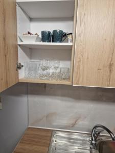 a cupboard with glasses and wine glasses on it at Nicolas luxury apartment in Amalias