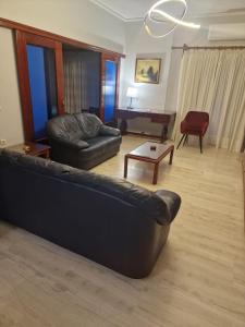a living room with a leather couch and a table at Nicolas luxury apartment in Amalias +4 photos