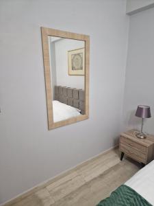 a mirror on a wall with a bed and a table at Nicolas luxury apartment in Amalias