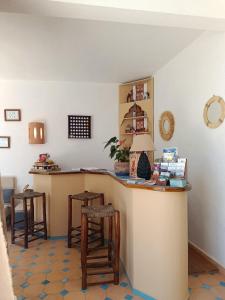 a kitchen with a counter and two stools at Villa Daba By Zelia in Ghazoua