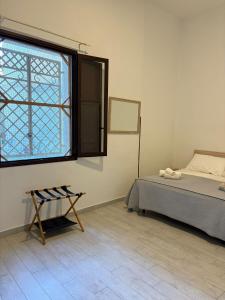 a bedroom with a bed and a window and a chair at Marsala al centro n9 in Marsala